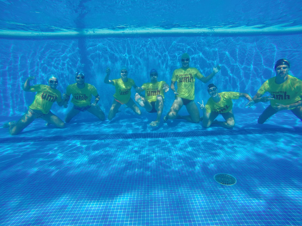 Foto de los monitores de la escuela de natación umh debajo del agua en la piscina